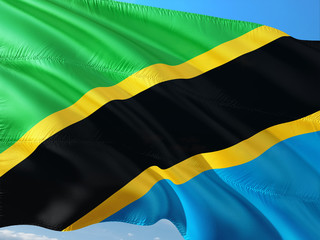 Flag of Tanzania waving in the wind against deep blue sky. High quality fabric.