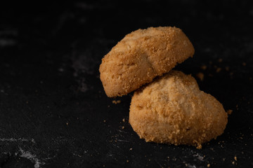 Butter cookies on the dark stone table, top view. Flat lay, overhead, from above. Copy paste Space for text.