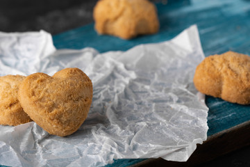 Healthy sweet cookies on a baking paper and blue wooden cutting board. Dark stone background Copy space. Close up