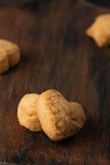 Homemade oatmeal cookies on the baked paper and dark wooden background, close up top view copy space