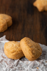 Homemade oatmeal cookies on the baked paper and dark wooden background, close up top view copy space