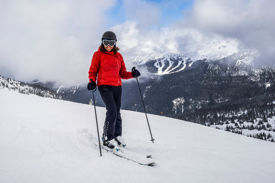 A Female Downhill Skier Poses For The Camera On A Ski Hill At A Ski Resort; Whistler, British Columbia, Canada