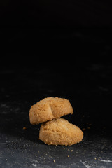 Close up view on cookies on a dark stone background. Sweet bakery coockie food. Dessert for coffee or tea. Homemade cuisine. Free copy paste space for text, logo