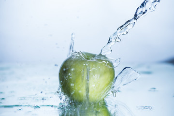 Fototapeta na wymiar Green apple with freezed water splash