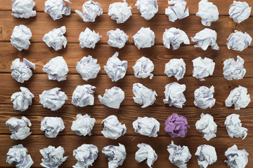 Concept of creativity and inspiration presented by many white paperballs and one color © adam121