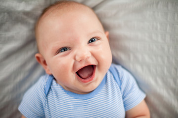 Laughing Baby Boy Lying on Bed