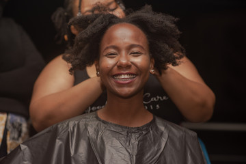 Young smiling woman getting her hair braided