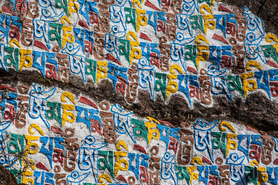 Colourful Tibetan script on a boulder in the Nepalese Himalayas; Nepal