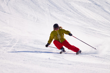 Young woman downhill skiing on an open slope at a ski resort in the Canadian Rocky Mountains, Alberta