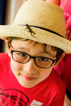 Boy with baby lizard on his tropical straw hat; Varadero, Cuba