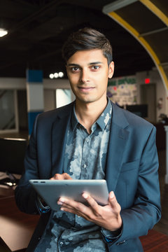 Young millennial businessman using his technology in the workplace; Sherwood Park, Alberta, Canada