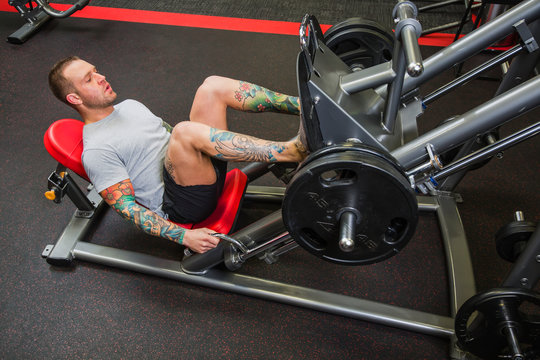A young man doing leg presses at a fitness facility; Spruce Grove, Alberta, Canada