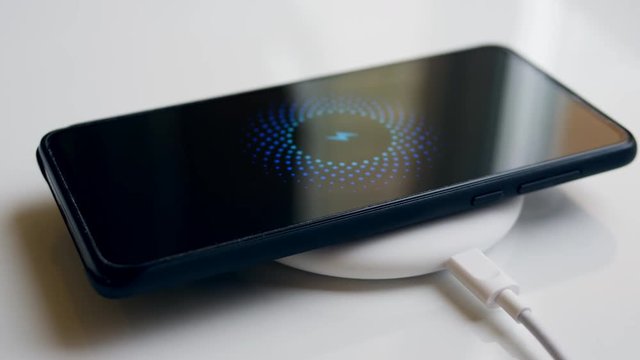 Mobile phone and a wireless charging device. Wireless charging concept.