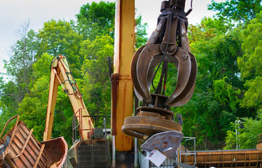 A powerful electromagnet picks up metal scrap  in salvage yard