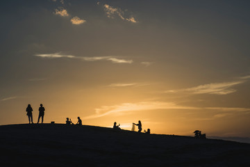 Fototapeta na wymiar people on sand dune in the sahara desert watching sunset