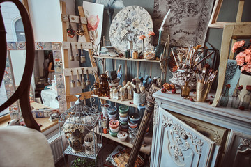 Bright artist's workshop with barocco elements, cage and flowers.