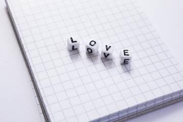 Love Liebe mit Buchstaben auf einem kariertem Block