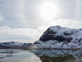 Fjord and mountain under halo sun in Lofoten island, Norway