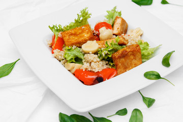 Healthy food. One white plates. Tomato salad, arugula, spinach, olives, pepper. White background