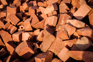 A pile of broken red building bricks is scattered on the ground.