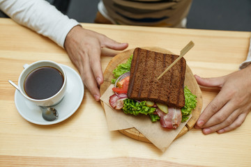 Man in cafe take his order sandwich and coffee