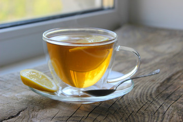 Cup of tea with lemon on wooden background. Copy space for your text.