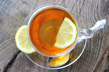 Cup of tea with lemon on wooden background. Copy space for your text.