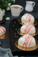 Homemade mousse cakes Hearts with white mirror icing on a dark background