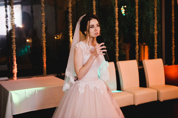 bride speaks at banquet on her wedding, the bride speaks into the microphone.