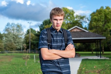 Angry student standing on a walkway that leads to a little pavilion.