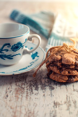 Chocolate cookies and empty mug on a wooden table.