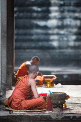 Buddhist monk offering blessings and accepting donations at Angkor Wat temple, Siem Reap, Cambodia