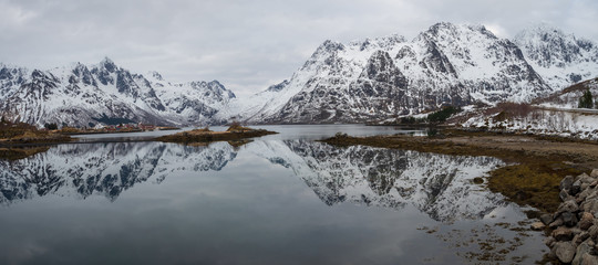 Fototapeta na wymiar Reflection of mountain on fjord during winter, Norway