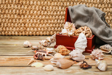 Close up Ancient casket for jewelry with collection of different seashells on wooden table.
