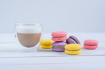 Sweet delicious colorful macarons and cup of coffee.