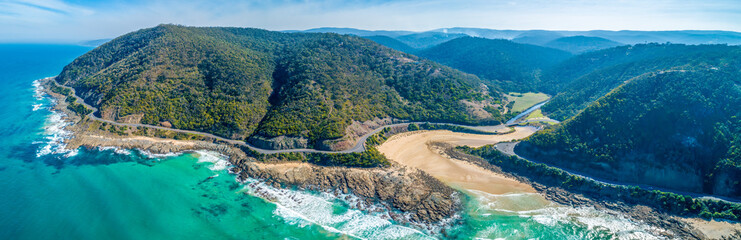 Wide aerial panorama of Great Ocean Road bending and winding along scenic coastline