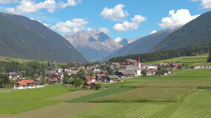 Fototapeta na wymiar DRONE: Flying towards a scenic village in the picturesque Austrian countryside.