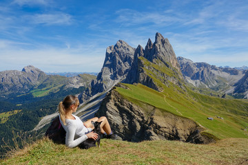 Fototapeta premium CLOSE UP: Female hiker relaxes on the mountaintop with her dog after a long hike