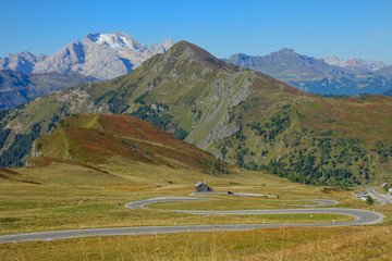 AERIAL: Flying over the pastures and towards a winding road in the mountains.