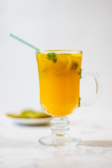 Freshly squeezed orange juice with pulp, kiwi and lemon on a light background. Vertical orientation