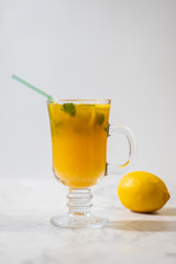 Freshly squeezed orange juice with pulp, kiwi and lemon on a light background. Vertical orientation