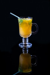 Freshly squeezed orange juice with pulp, kiwi and lemon on a dark background. Vertical orientation