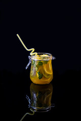 Freshly squeezed orange juice with pulp, kiwi and lemon on a dark background. Vertical orientation