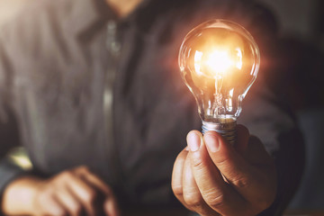 hand holding light bulb. idea concept with innovation and inspiration - Powered by Adobe