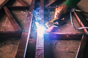 close up hand welding steel with spark