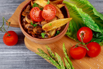 Oven fried potatoes and roasted mushrooms, fresh vegetables grilling