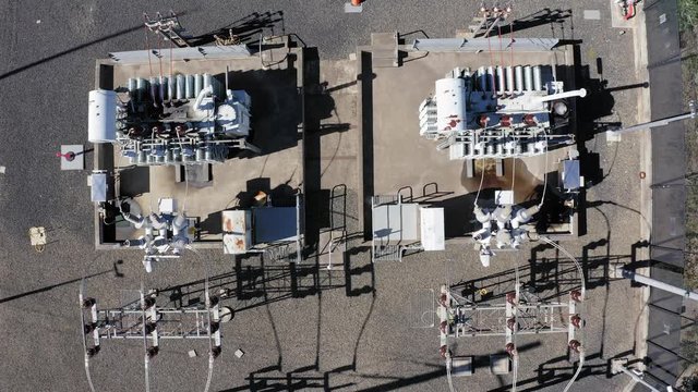 Aerial shot of transformers at a power electrical sub station from above - panning