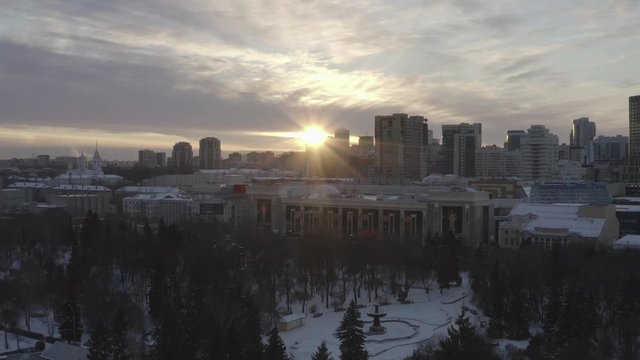 Idyllic aerial view of modern city buildings, park and church at the sunset in winter. Action. City winter landscape