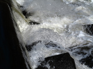 River Rapids - Foamy waters flow quickly through black rocks. 