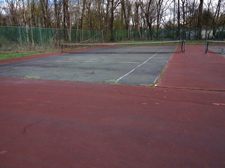 Tennis Courts - Neglected courts with cracks and debris.